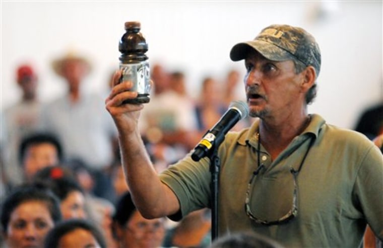 A.C. Cooper, vice president of the Louisiana Shrimp Association, holds a bottle of oil as he pleads to Ray Mabus, U.S. secretary of the Navy, to ensure the safety of Louisiana seafood during a town hall meeting for fishermen and residents in Buras, La. 